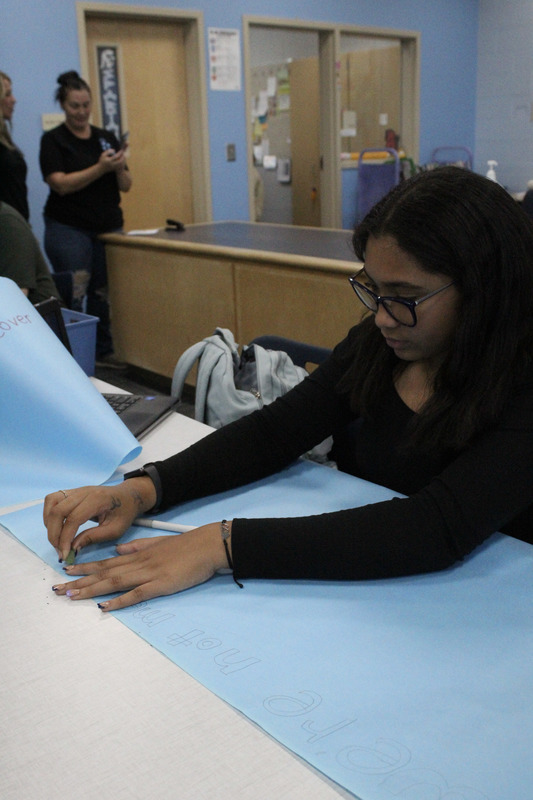Student making Hope Week Poster