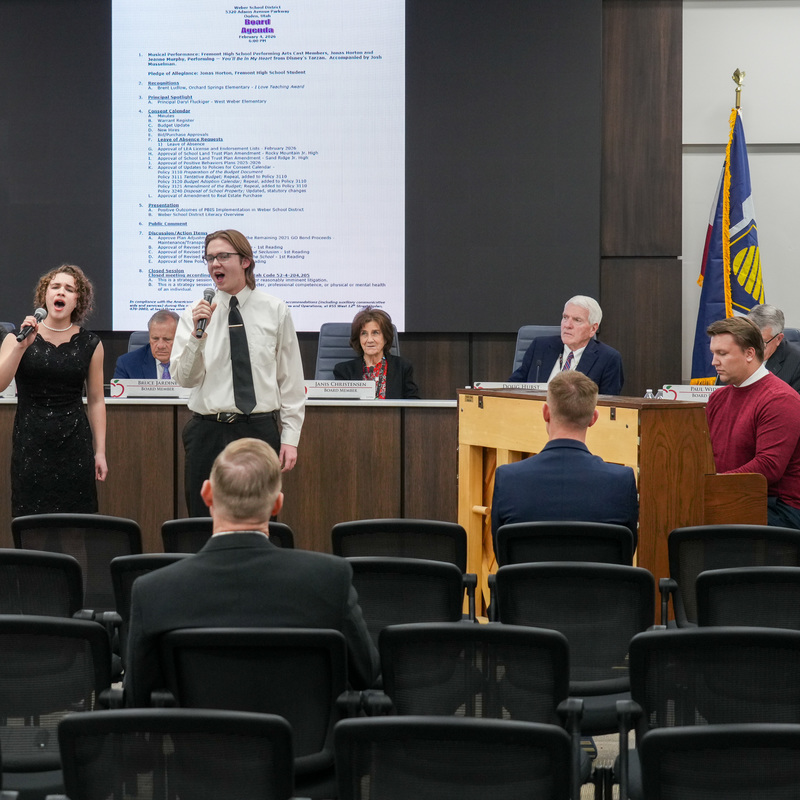 Students singing at board meeting
