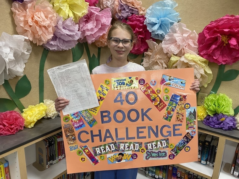 Student holding the 40 book challenge Poster