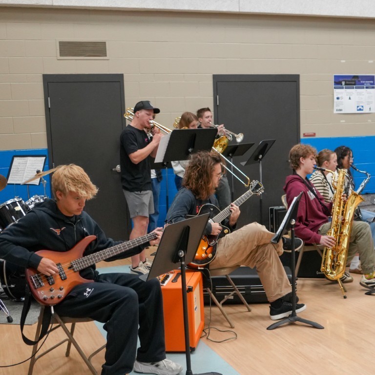 A student jazz band performing live in the gymnasium to celebrate the Principal of the Year announcement.