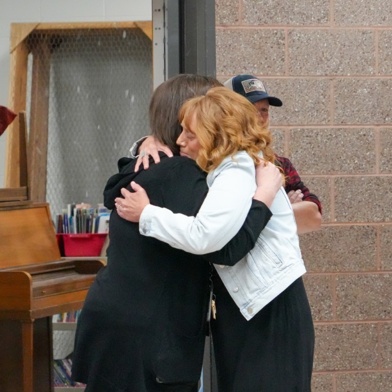 Principal Kari Breeding sharing an emotional embrace with a colleague during her Utah Principal of the Year celebration.