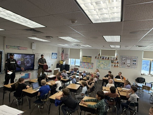 Police officers talking to 3rd grade students in a classroom