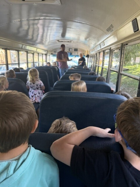 bus drivers talking to kindergarten students in a schoolbus