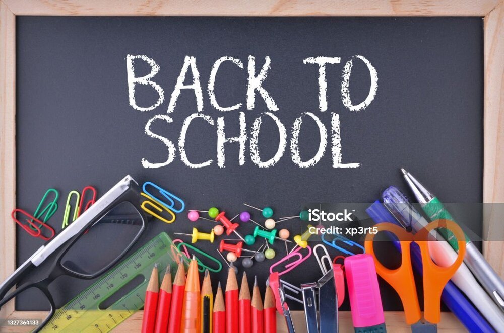 a blackboard with white text reading "back to school" and various school supplies