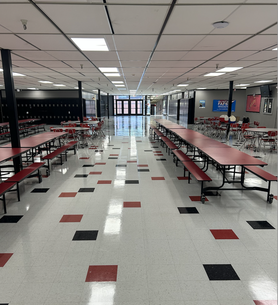 School cafeteria with freshly waxed floors and tables set up, ready for the first day of school.