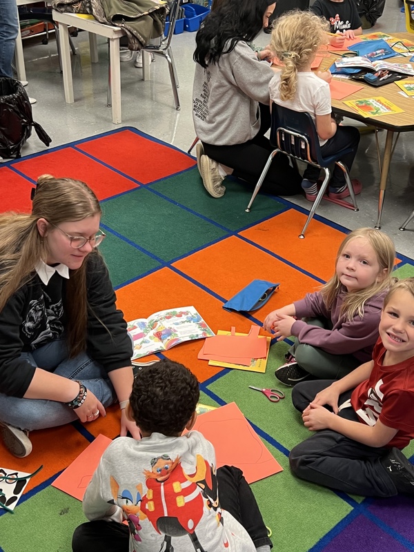 Children on a rug working on a craft