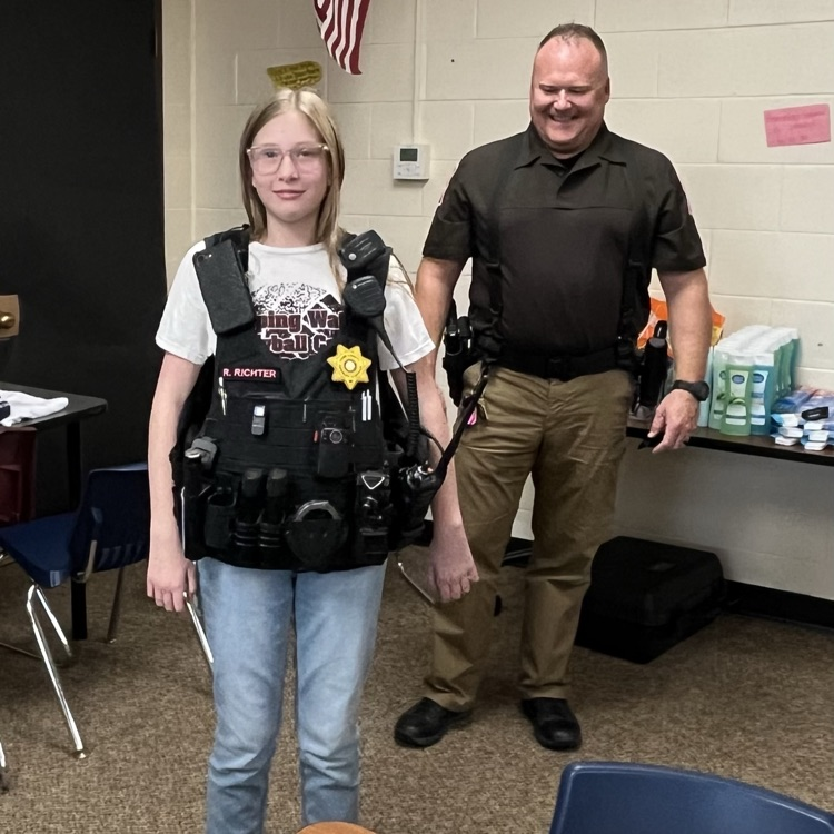 Izabel feels how heavy the Captain’s vest is.