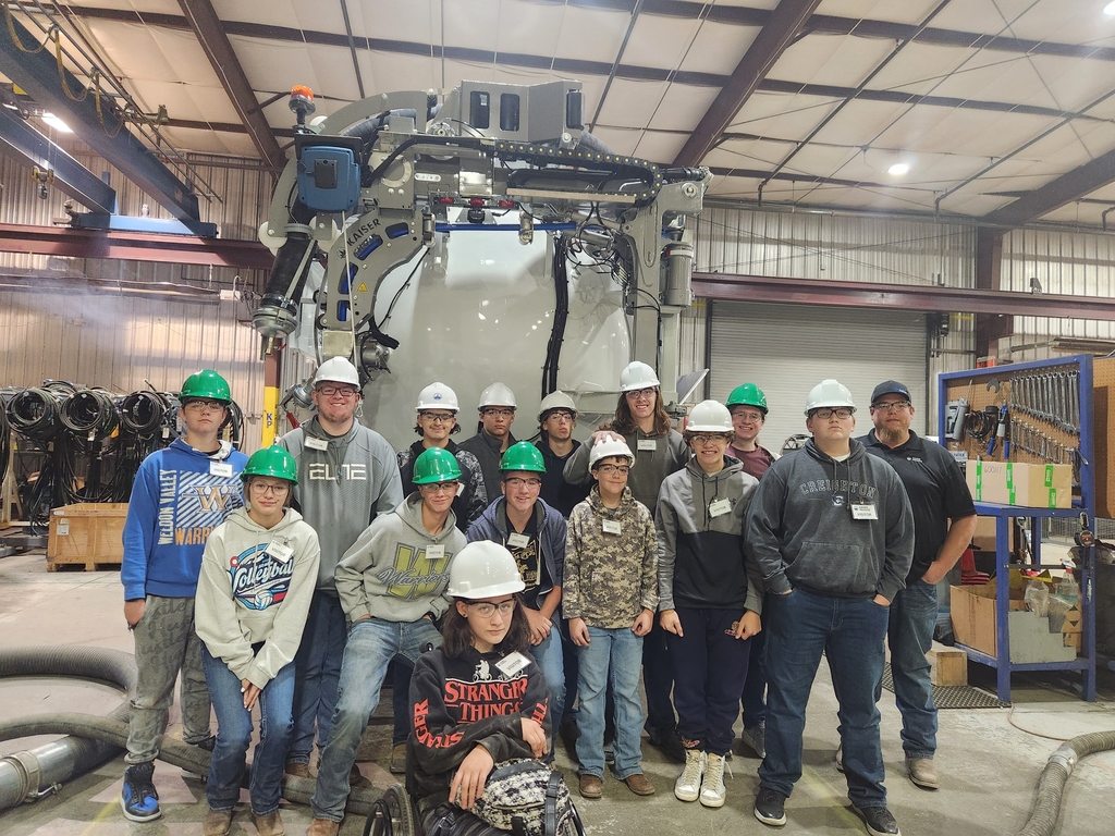 A group of students in front of a hydro vac truck 