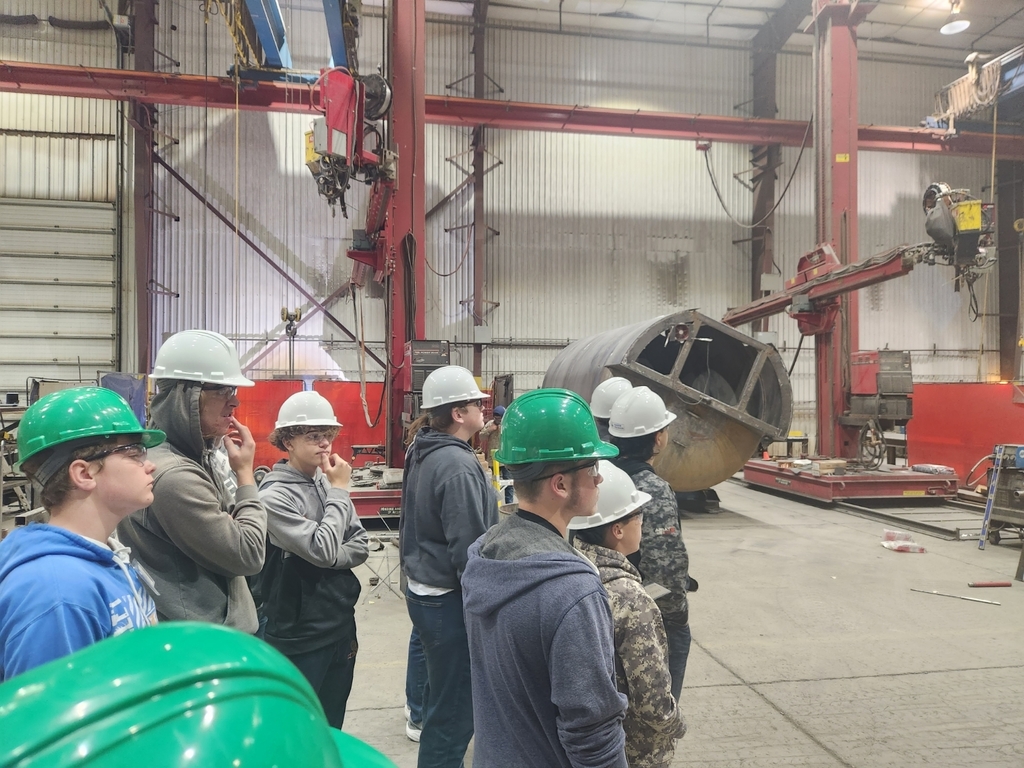 Students looking at a welded tank