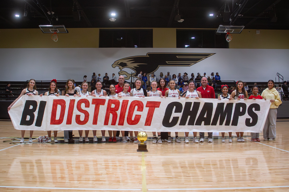 Lady Skyrockets pose with the Bi District Champs sign and gold ball