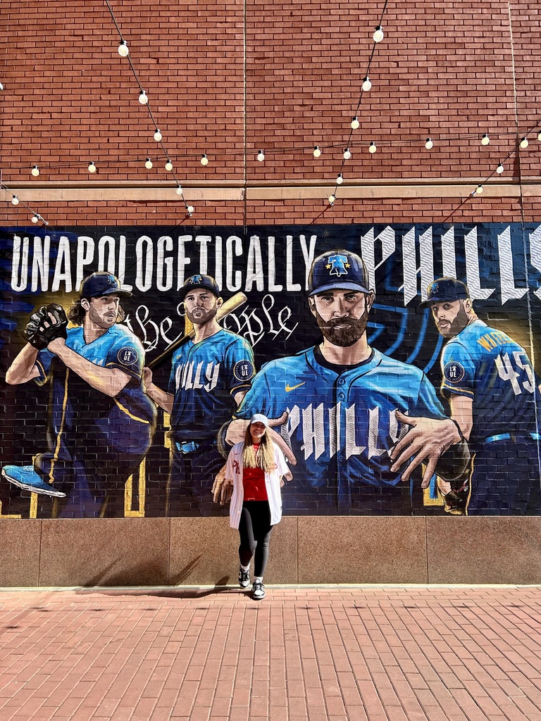 Woman in fron to Phillies sign