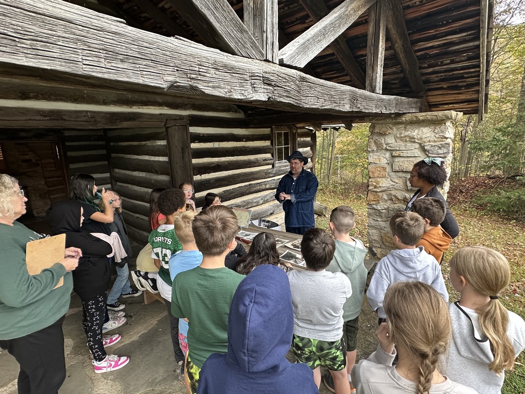 Students in front of log cabin