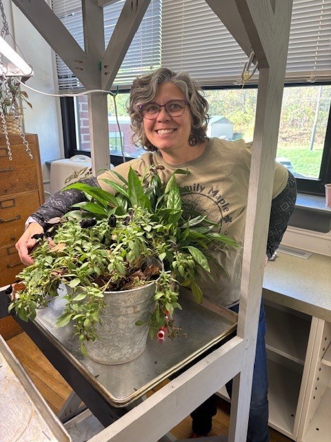 Teacher standing behind plants
