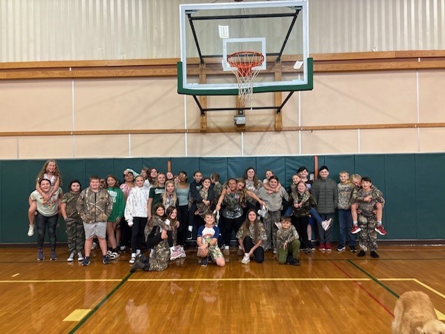 Students in camo under basketball hoop