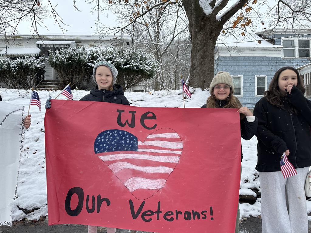 Students holding Veteran's day sign