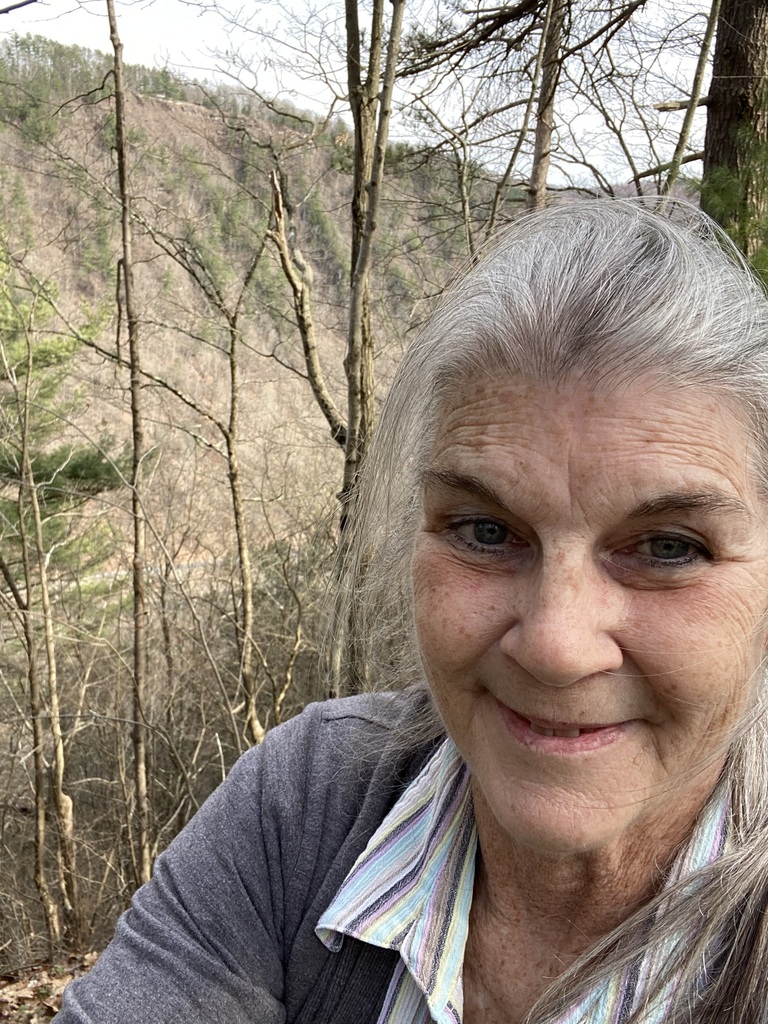 Woman with trees behind her