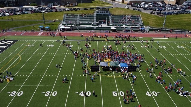 Drone picture looking towards the stadium with people on the field.