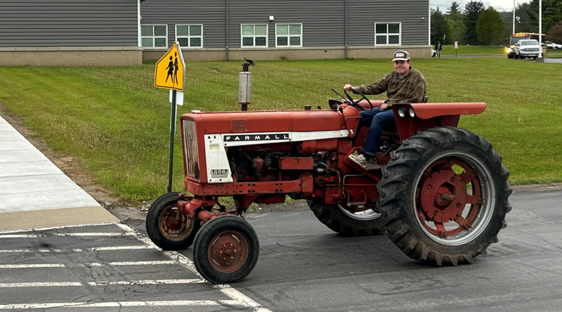 A student driving his tractor to school.