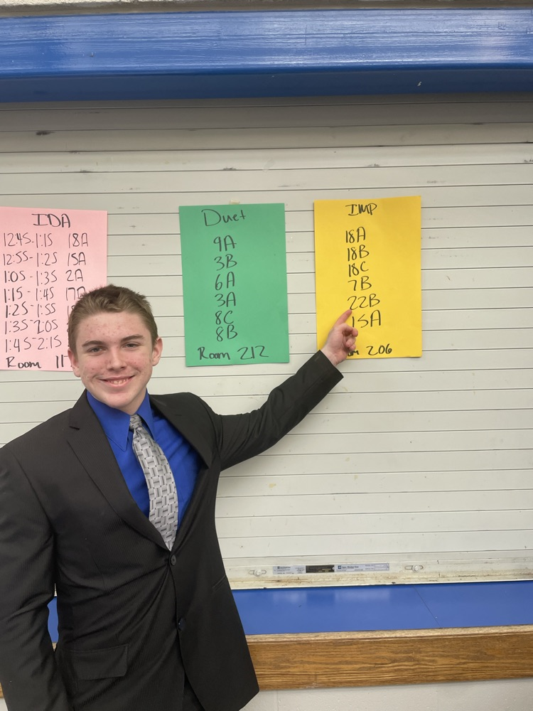 Eston pointing to his code on the poster