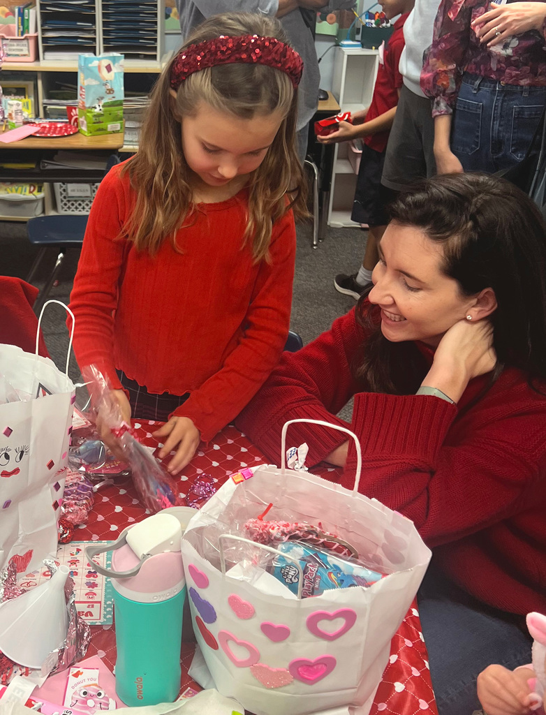 1st grade student in class with her mom.