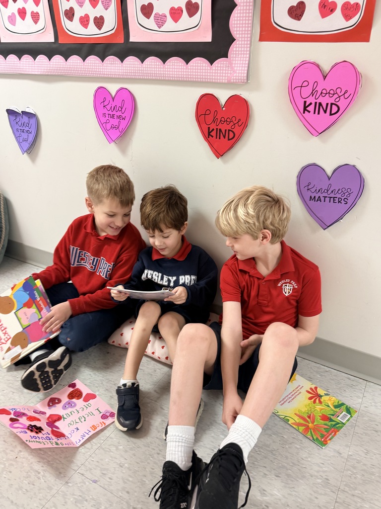 PreK 4 and 1st grade students reading together.