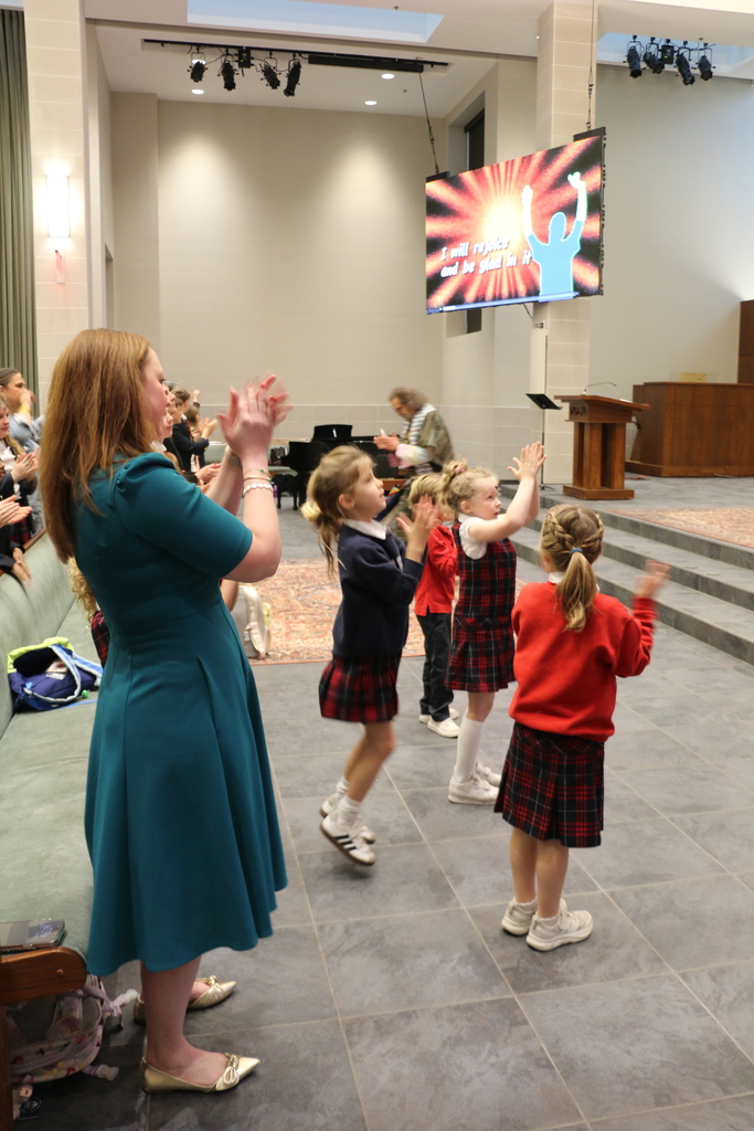 Meg Fahrenbrook sings and dances with students during the Ash Wednesday service.