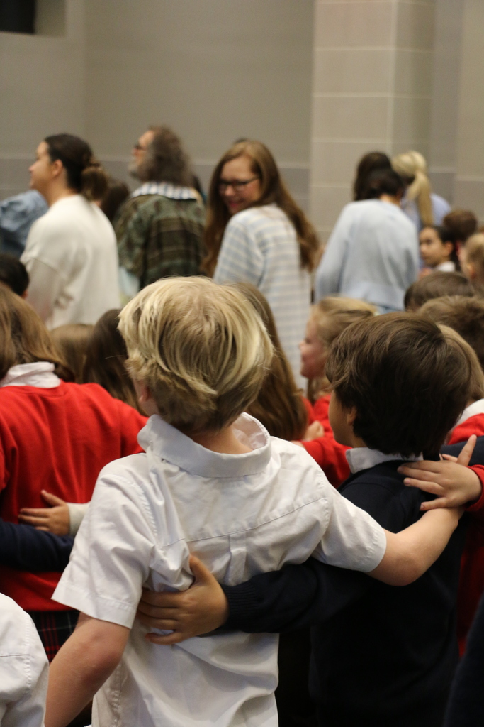 Students embracing in song during the Ash Wednesday service.