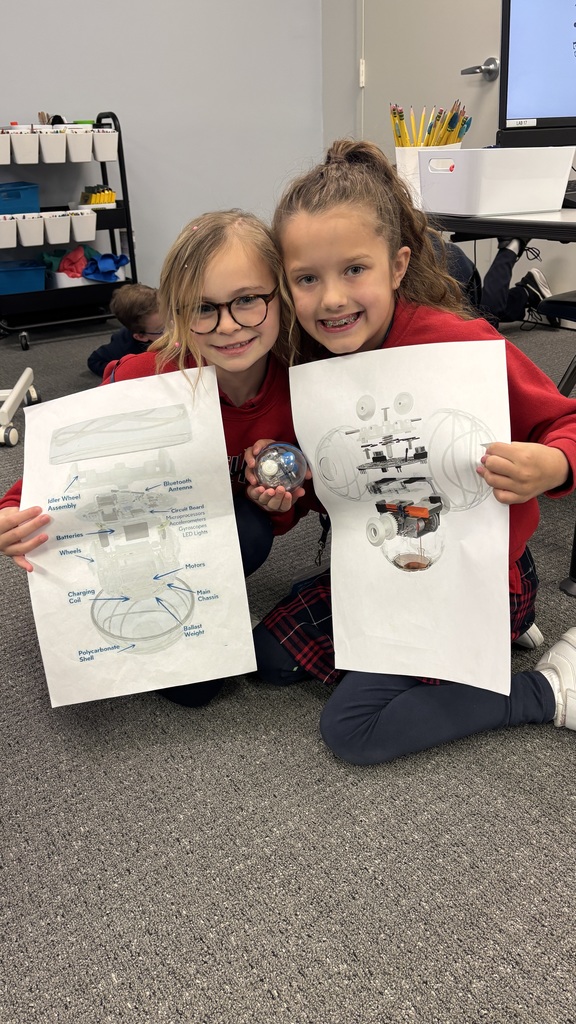 Third graders smiling for a photo as they learn about a robot.