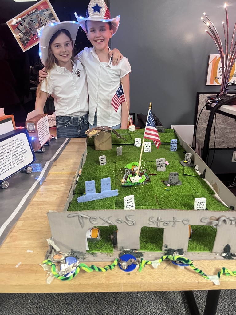 Two fourth graders pose with their art project.