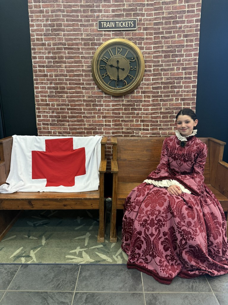 5th grade student who portrayed Clara Barton poses in front of her vignette.