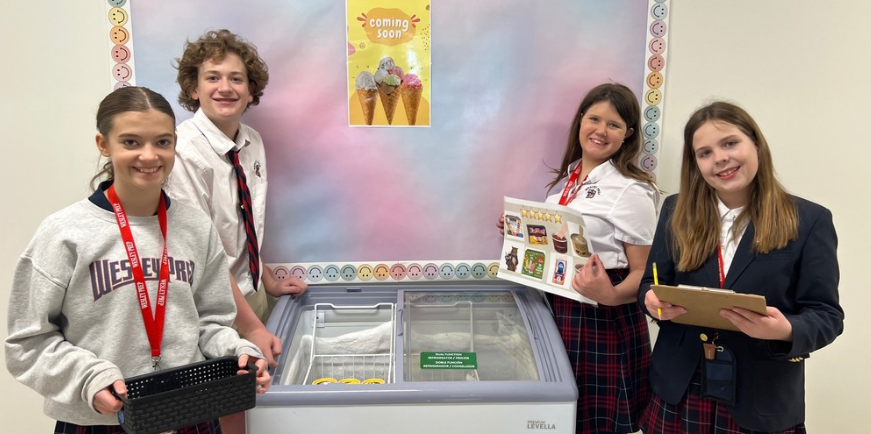 Student council members pose in front of their ice cream freezer.
