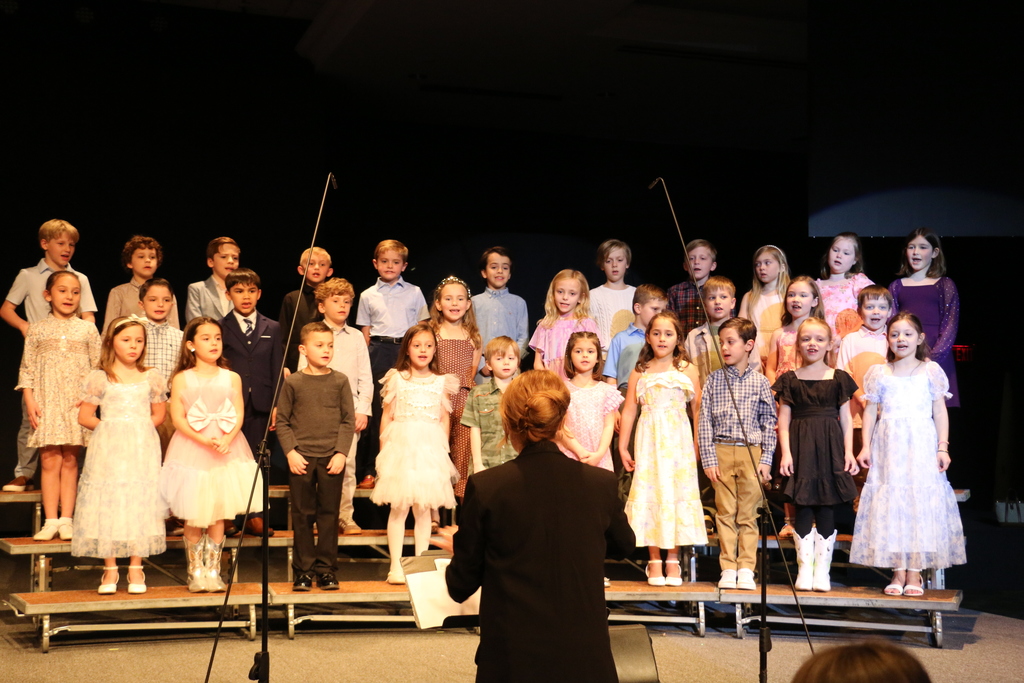 First grade students sing.