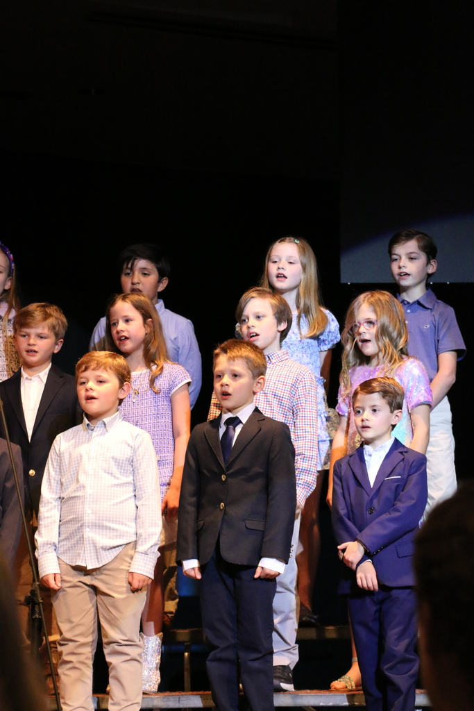 Second grade students sing.