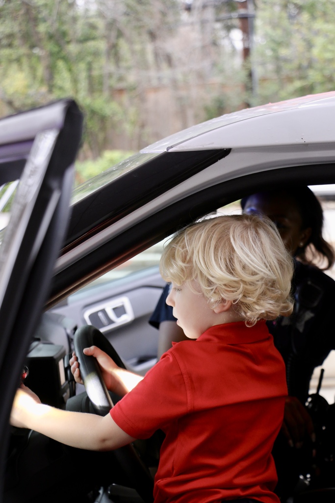 A student adjust the lights on the side of a police car.