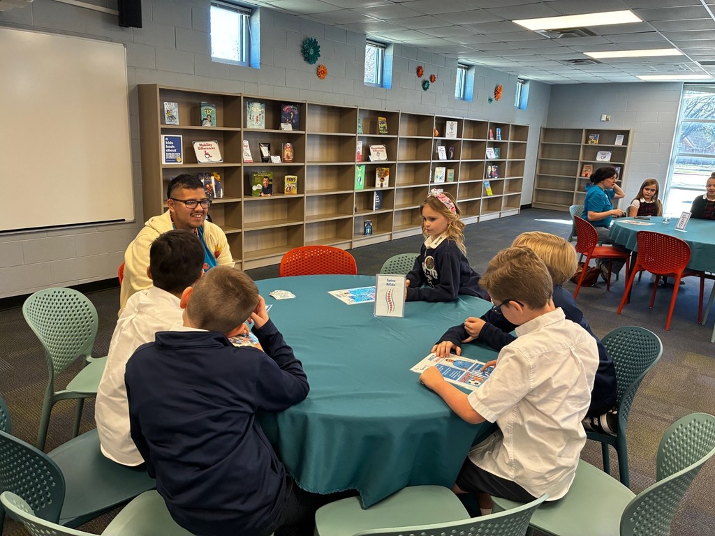 Some third grade students discussing at a round table with a To Be Like Me representative.