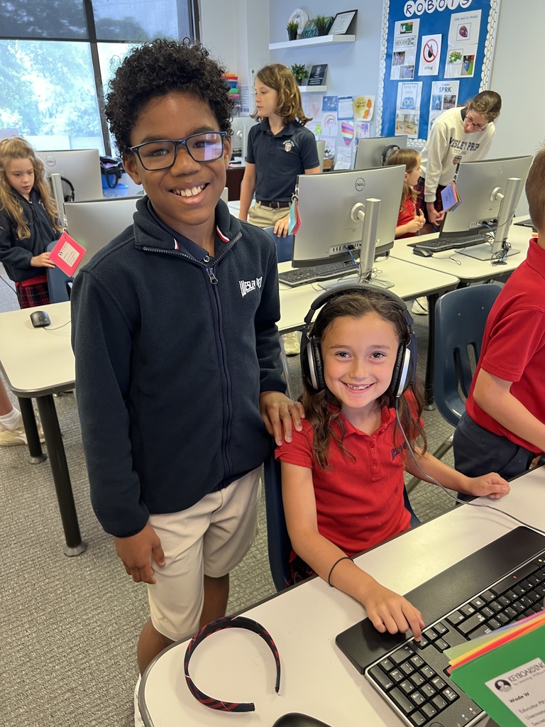 Fifth grader smiling with Primer student while they play games!