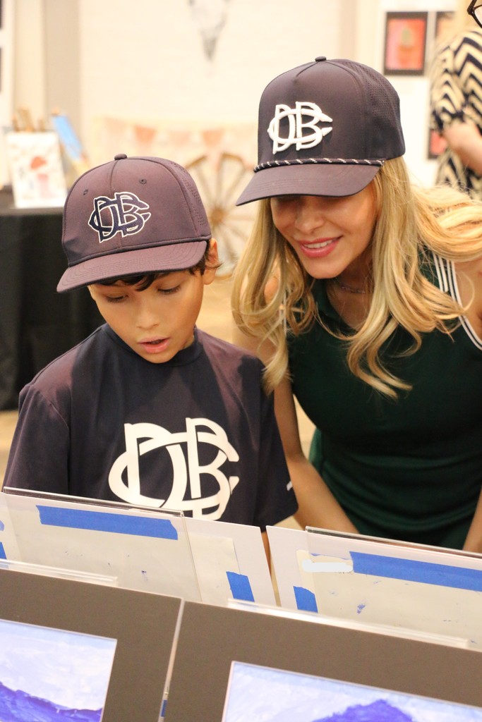 Student showing his art to his mom.