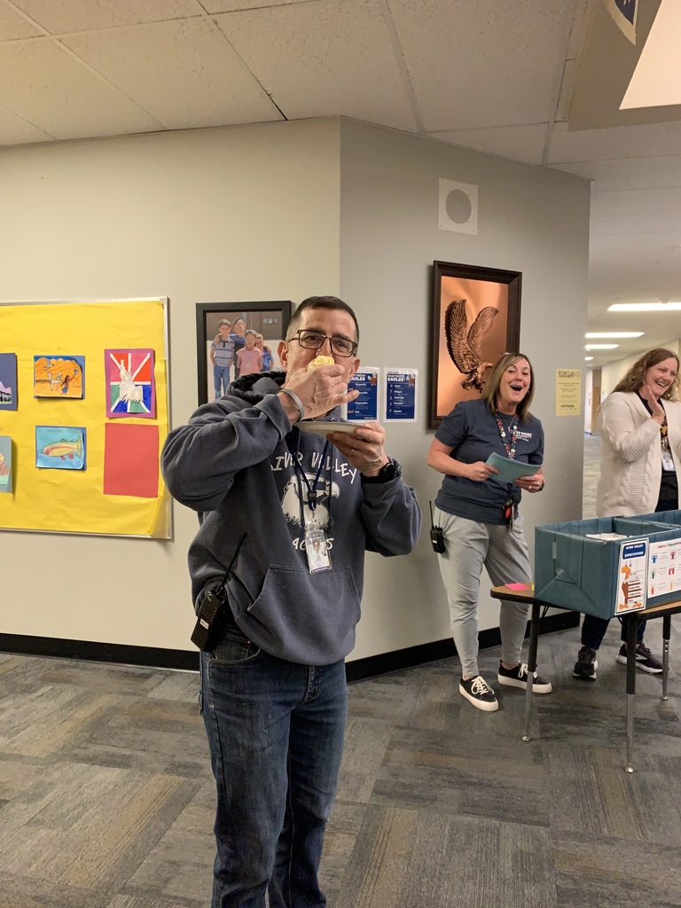 Man eating cake with women laughing in background