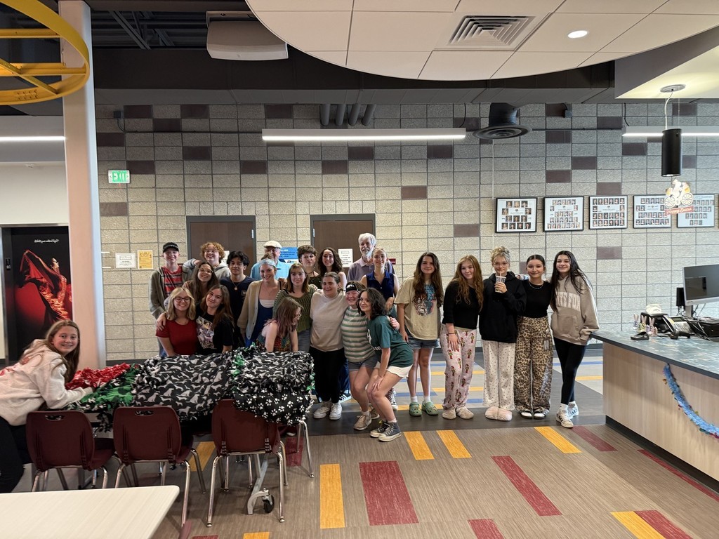 Students posing. Students worked on tie blanks for Threads of Compassion