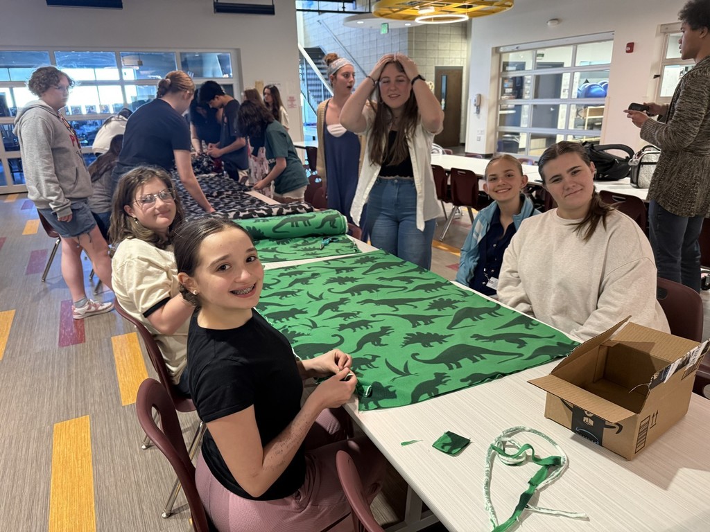 Students working on tie blanks for Threads of Compassion
