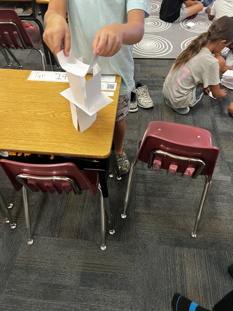 Student building a tower on a desk
