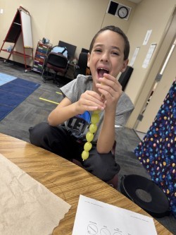 Student enjoying a skewer of grapes