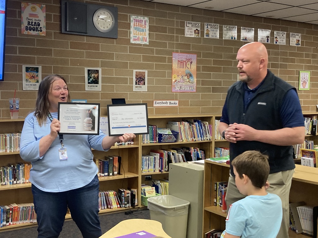 Ms. Gillenwater holding her grant for outdoor environmental seating project
