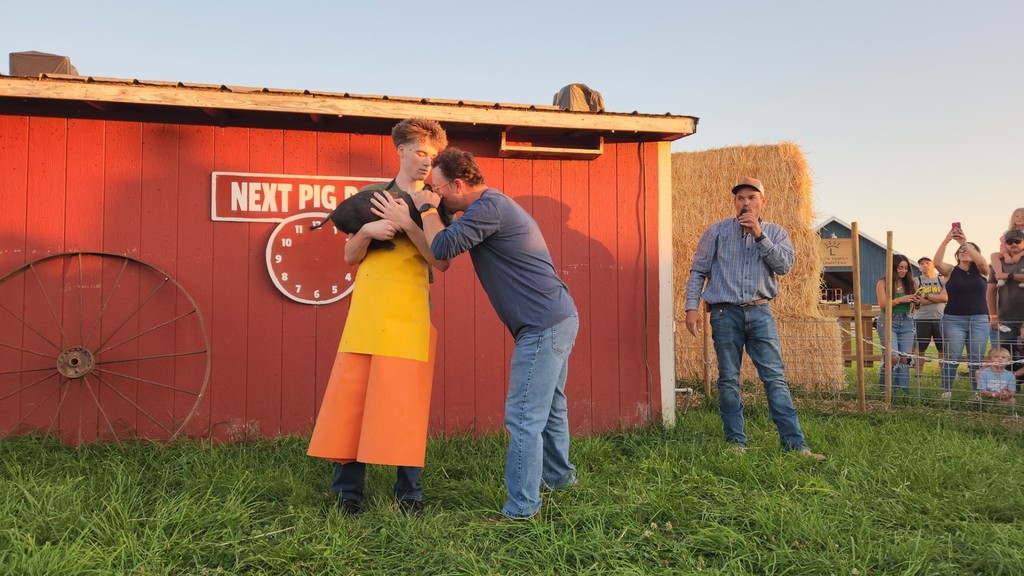 Mr Jensen kisses the pig at Farmstead