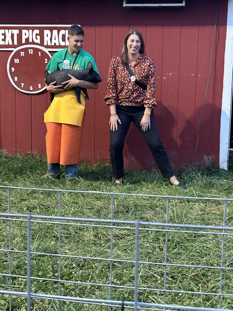 A photo of the principal getting ready to kiss a pig