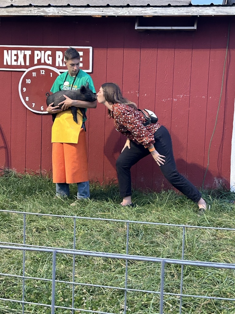 A photo of the principal kissing a pig
