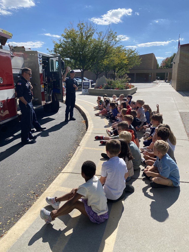 first graders learning from firemen outside