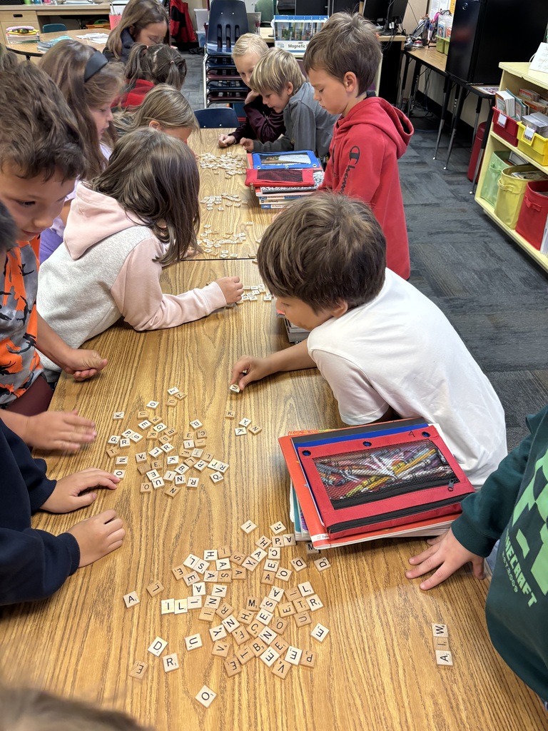 students working on desktops. with spelling tiles