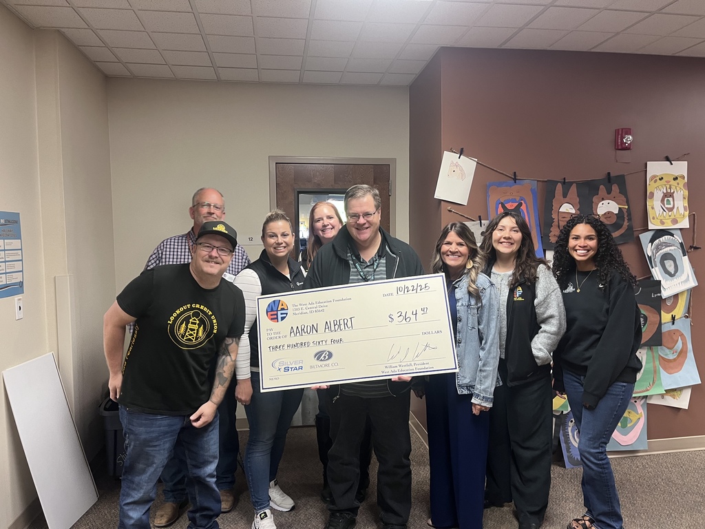 Mr. Albert holding a check as a grant winner. 