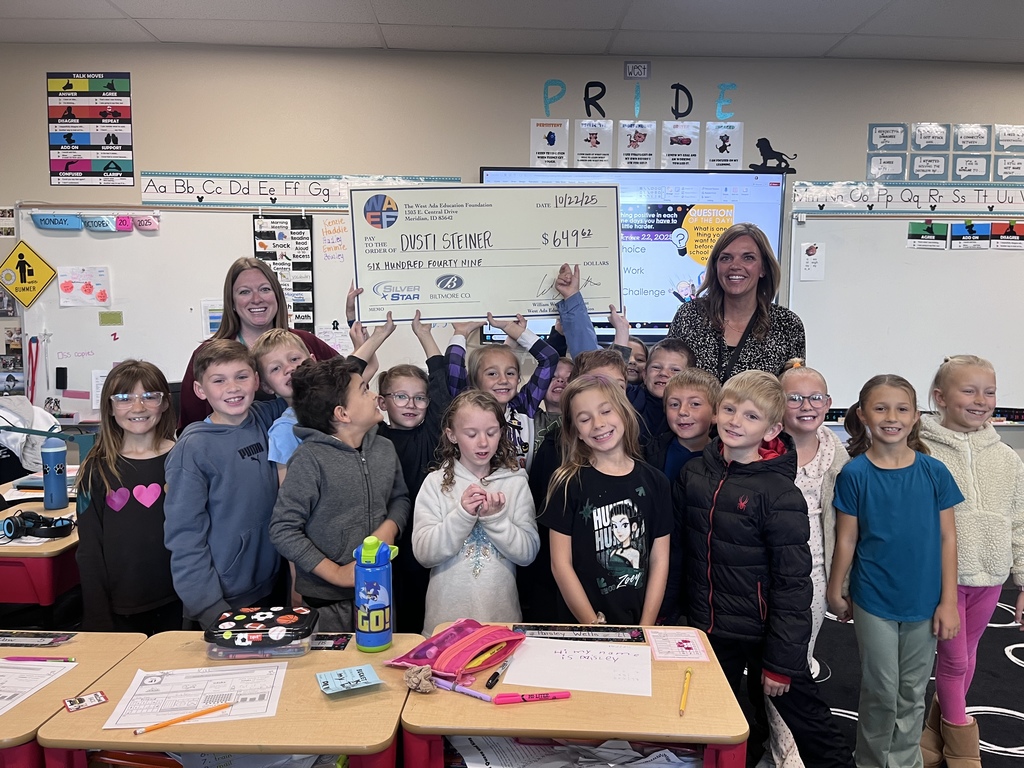 Mrs. Steiner holding a check as a grant winner. 